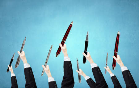 Many hands of business people holding penの写真素材