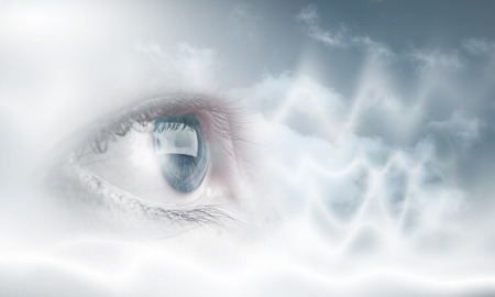 Female blue eye on cloudy sky backgroundの写真素材