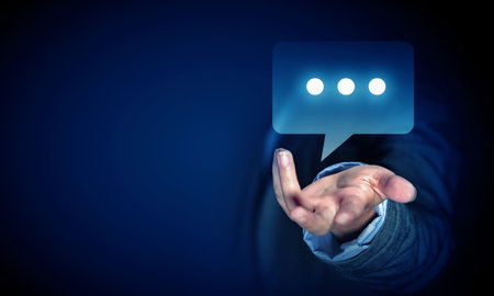 Hand holding speech bubble on blue backgroundの写真素材