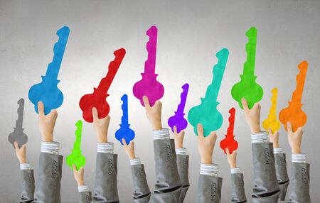 Many hands of business people holding keysの写真素材