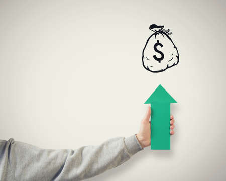 Hand holding rising arrow representing business growthの写真素材