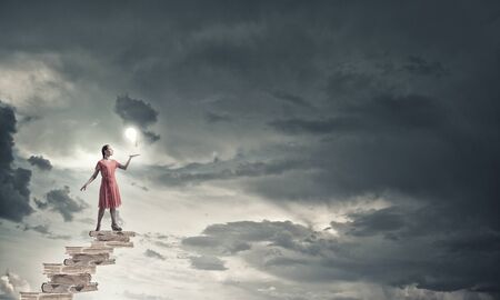 Young woman in red dress with book in handの写真素材