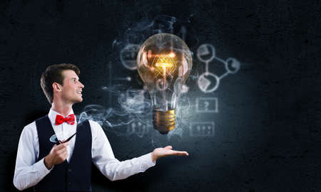 Handsome young businessman thinking over ideas and smoking pipeの写真素材