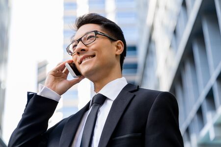 Businessman in city holding his mobileの写真素材