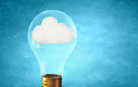 Glass light bulb with white cloud inside on blue backgroundの写真素材