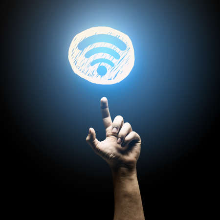 Person hand pointing with finger at glowing iconの写真素材