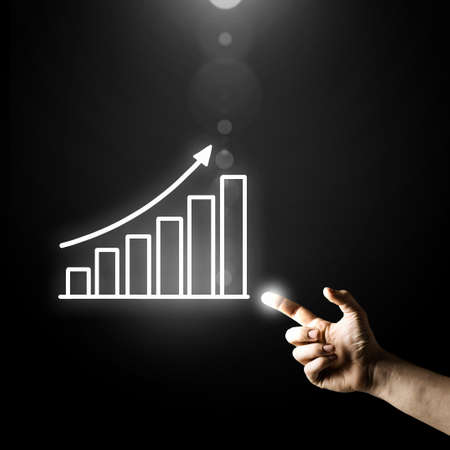 Human hand pointing with finger at growing graphの写真素材