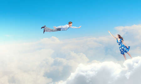 Happy young woman dreaming to fly in skyの写真素材