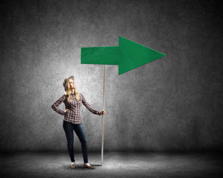 Young girl with arrow signbord in empty roomの写真素材