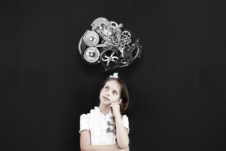 Cute thoughtful school girl and gear mechanism above her headの写真素材