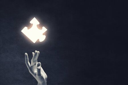 Close up of businessman's hand touching abstract puzzle pieceの写真素材