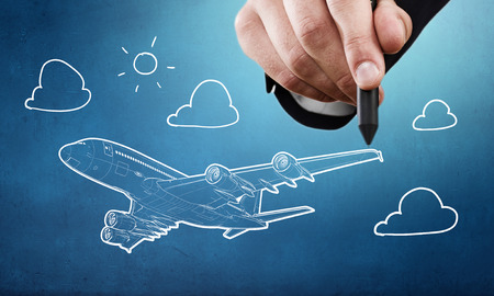 Person drawing airplane model on sky backgroundの写真素材