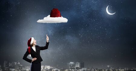 Santa woman pointing up on red bag with fingerの写真素材