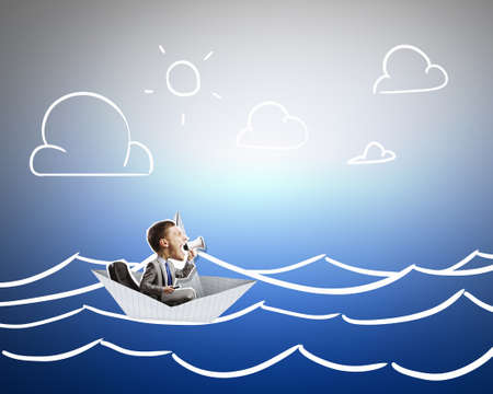 Businessman escapes from the crisis on a paper boatの写真素材
