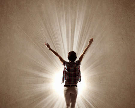 Rear view of woman with hands up facing successの写真素材