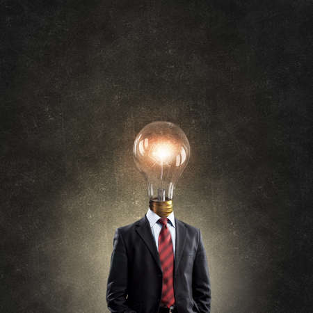 Businessman in suit with light bulb instead of headの写真素材