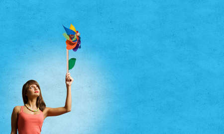 Happy young woman with windmill in handの写真素材