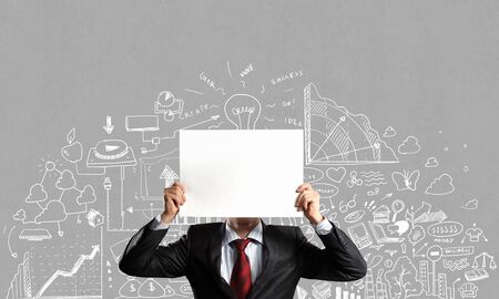 Unrecognizable businessman holding paper covering her faceの写真素材