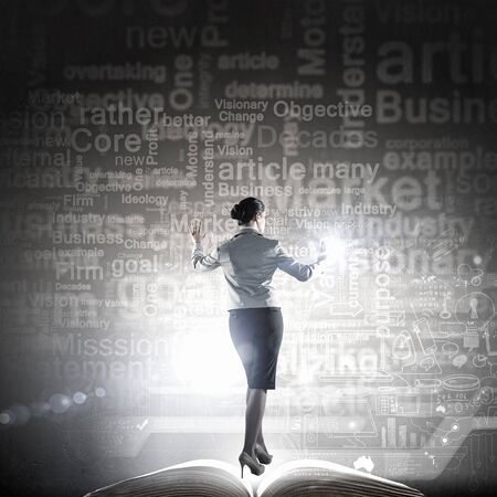 Back view of businesswoman working with digital virtual panelの写真素材
