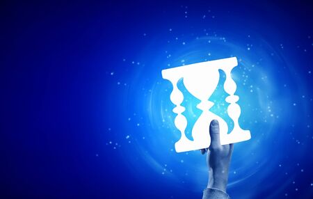 Close up of businessman holding sandglass sign in handの写真素材