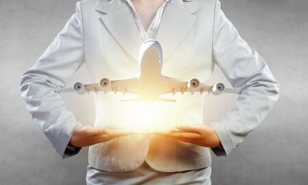 Close up of businesswoman hands holding airplane signの写真素材