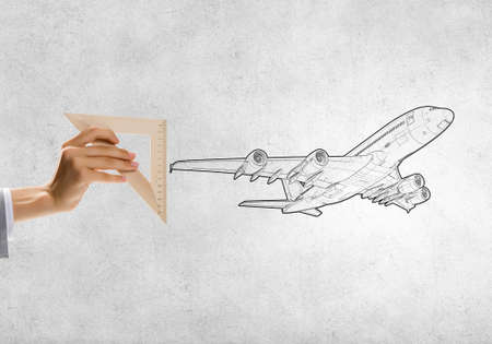 Close up of people hands measuring airplane wih rulerの写真素材