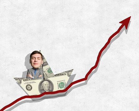 Businessman escapes from crisis on paper boat made of dollar banknoteの写真素材