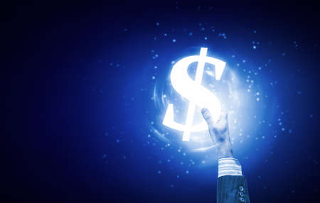 Close up of human hand holding dollar symbol on blue backgroundの写真素材