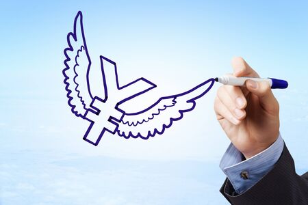 Businessman hand drawing yen flying sign on sky backgroundの写真素材