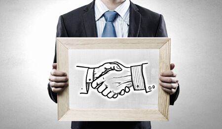 Unrecognizable businessman holding chalkboard with partnership concept sketchesの写真素材