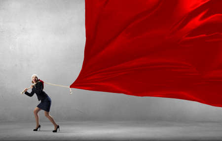 Santa woman in suit pulling red clothing bannerの写真素材