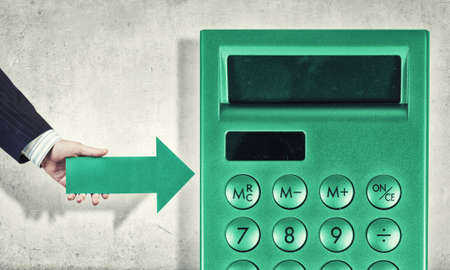Businessman hand with arrow pointing at calculatorの写真素材