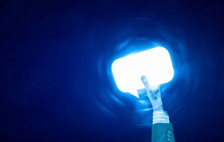 Person hand holding glowing email symbol on blue backgroundの写真素材