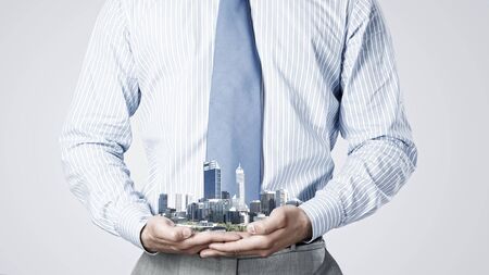Close up of businessman holding in hands construction modelの写真素材