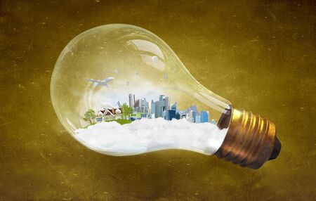 Think green concept with cityscape inside of light bulbの写真素材