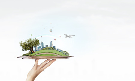 Hand holding metal tray with modern cityscapeの写真素材