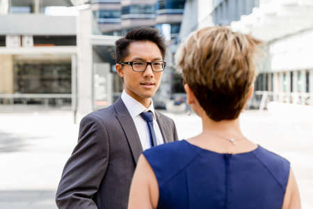 Business people having a talk while walking in a businesss districtの写真素材