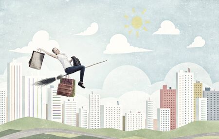 Happy young woman flying in sky on broomの写真素材