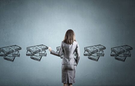 Back view of businesswoman drawing money banknotes on wallの写真素材