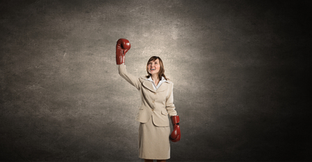 Young businesswoman in red boxing gloves competition readyの写真素材