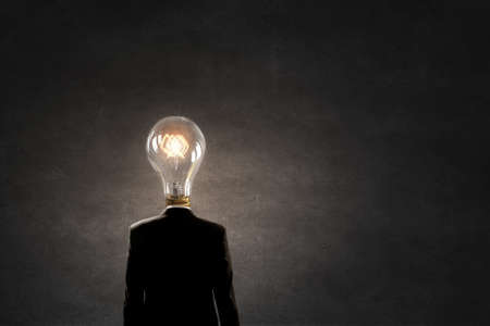 Businessman in suit with light bulb instead of headの写真素材