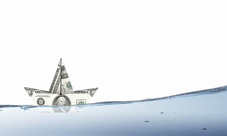 Ship made of dollar banknote floating in waterの写真素材