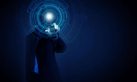 Young businessman pressing high tech circle icon on media screenの写真素材
