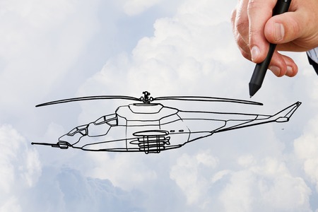 Person hand drawing helicopter model ob sky backgroundの写真素材