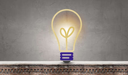 Conceptual image of light bulb on wall with sketches of ideasの写真素材