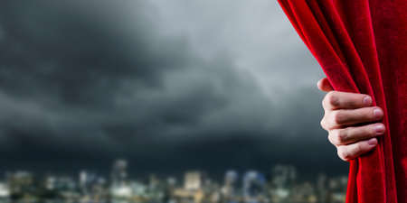 Close up of hand opening red curtain. Place for textの写真素材