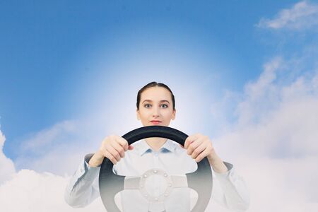 Young smiling pretty woman driving steering wheelの写真素材