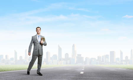 Young handsome businessman with old book in handsの写真素材