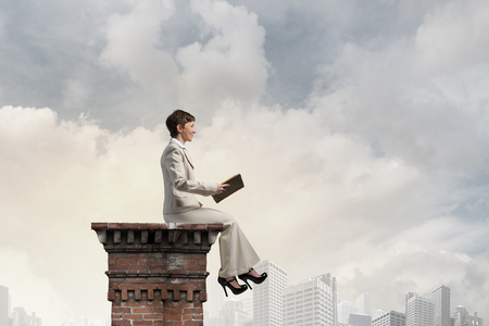 Adult woman in suit with old book in handの写真素材