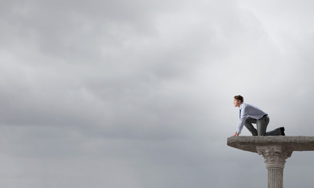 Young determined businessman in starting position ready to compete